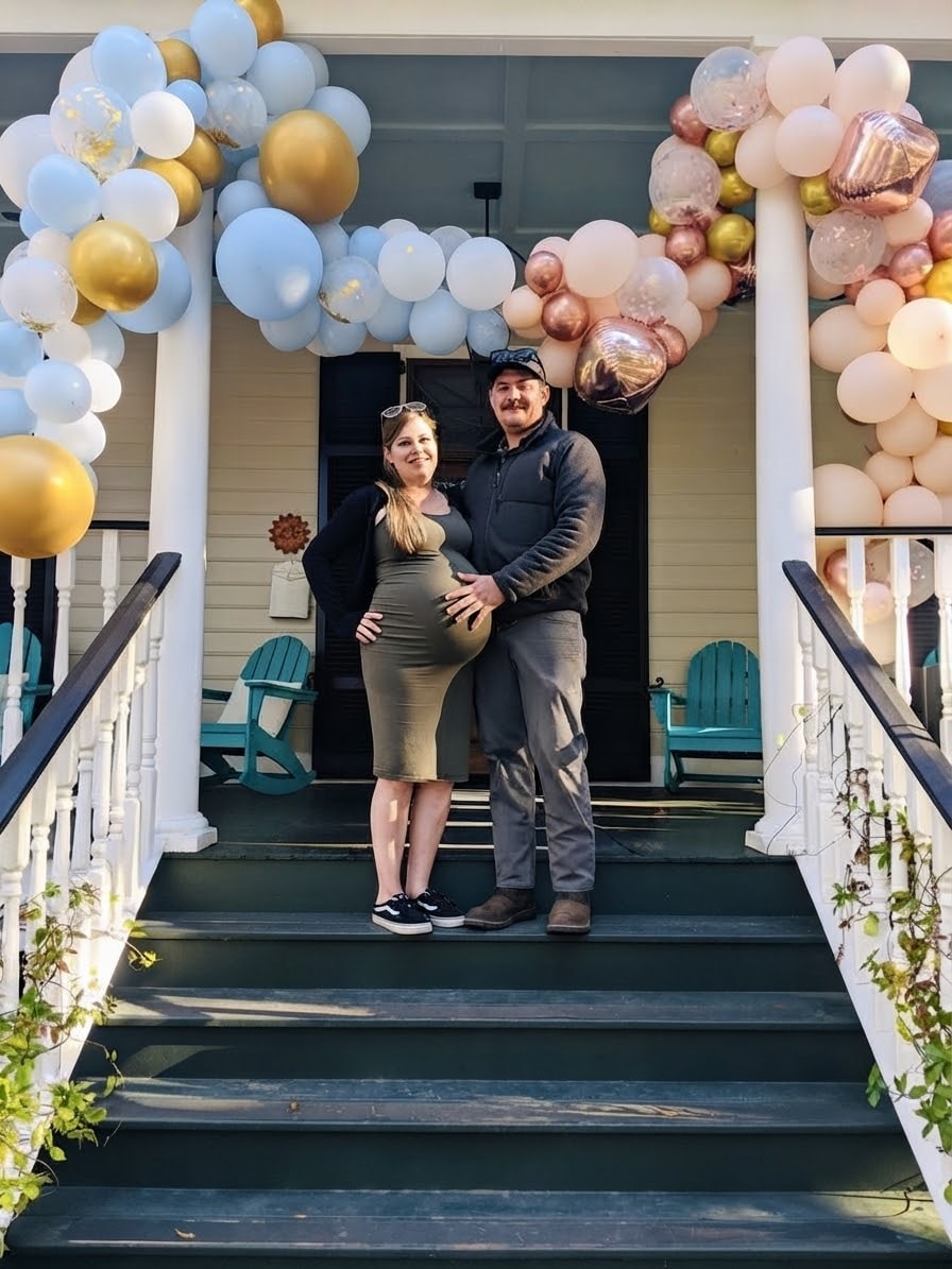 Baby shower couple on the porch steps with balloon arch